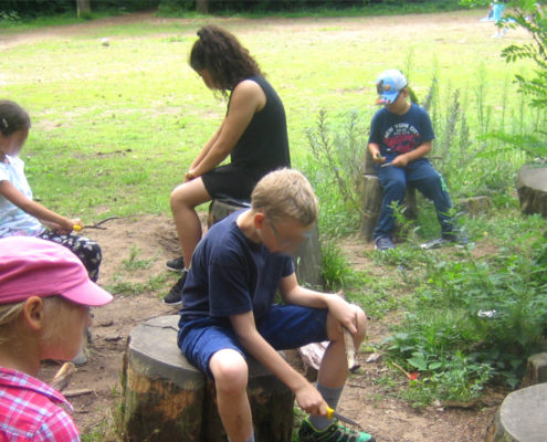 Kinder beim Schnitzen im Wald