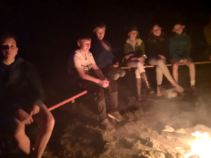 Kinder sitzen am Feuer