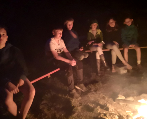Kinder sitzen am Feuer