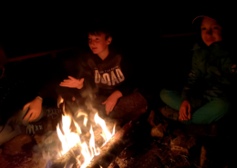 Kinder sitzen am Feuer III