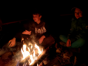 Kinder sitzen am Feuer III