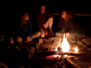 Kinder sitzen am Feuer II