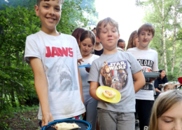 Kinder stehen Schlange mit ihren Pizzen